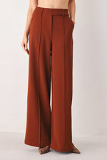Rust woven wide-leg pants with belt loops and vertical front seams