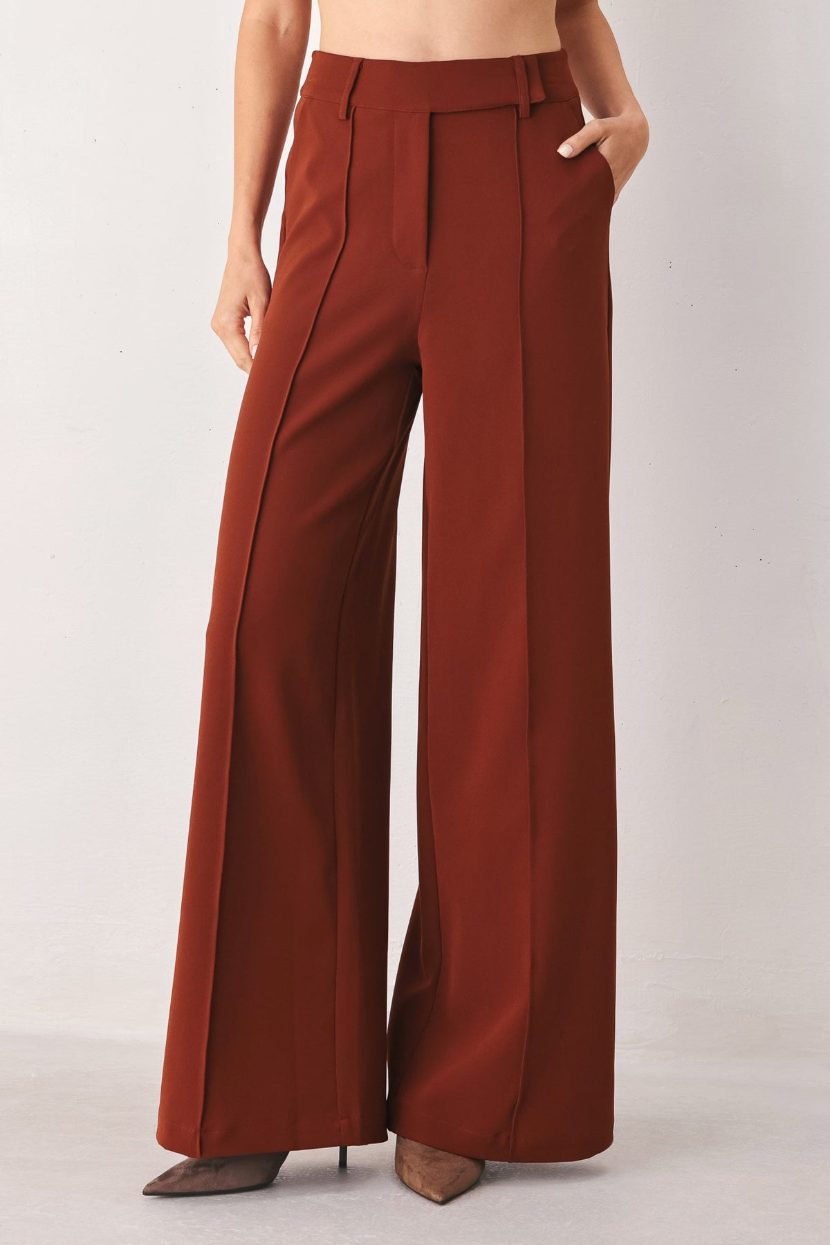 Rust wide-leg woven pants with draped legs and button waistband detail