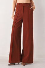 Rust wide-leg woven pants with draped legs and button waistband detail