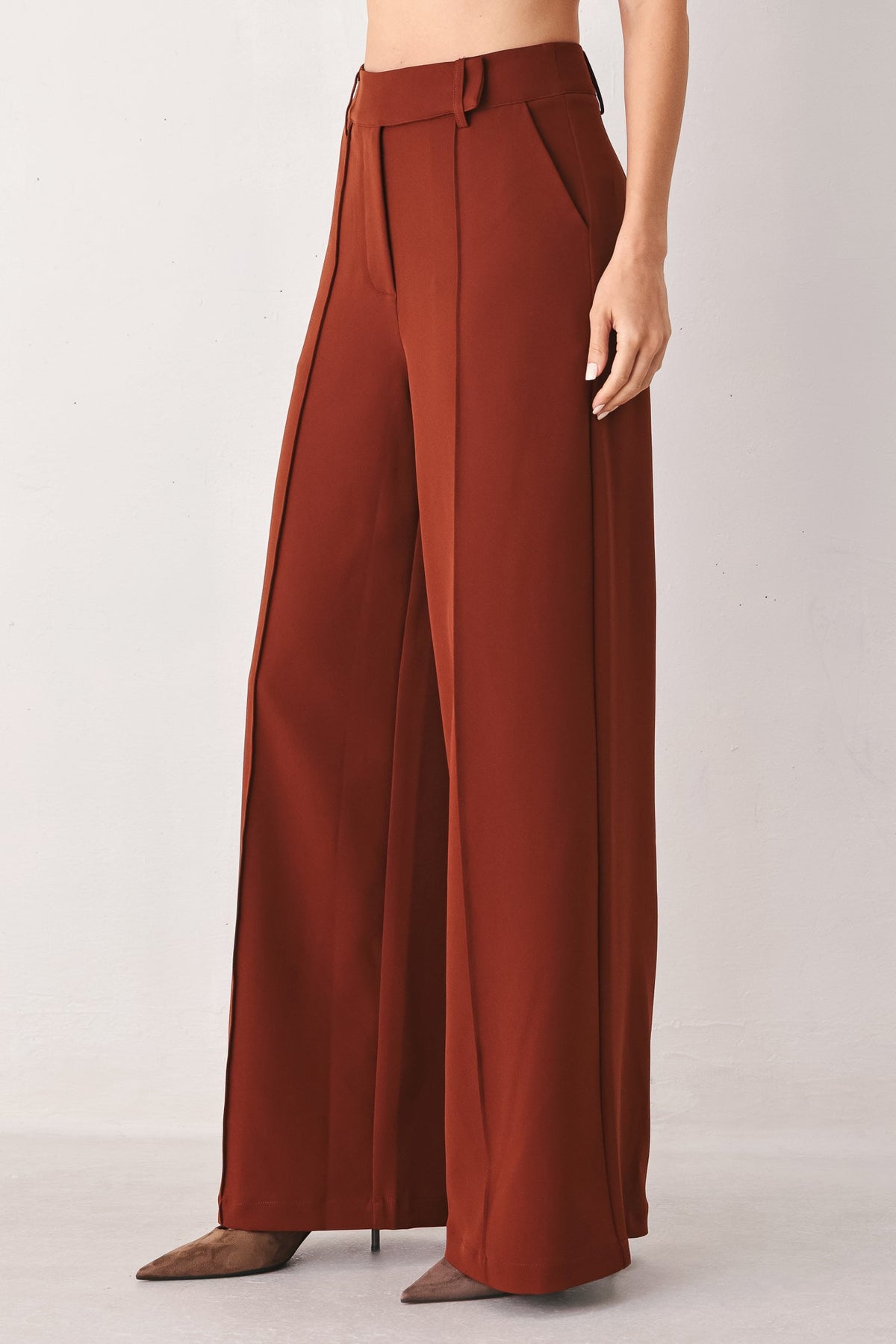 Rust woven wide-leg trousers with relaxed flowy legs and button front