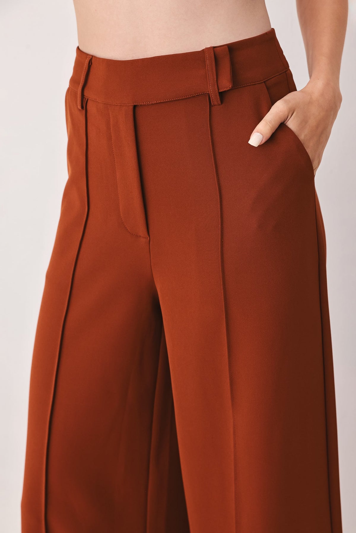 Rust high-waist wide-leg pants with belt loops and stitched pocket openings