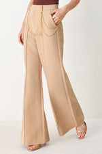 Camel wide-leg woven pants with long drape chain across the hip