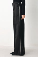Black wide-leg woven pants showing full length with white side stripe