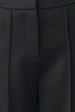 Black pants close-up of front pleats and seam lines