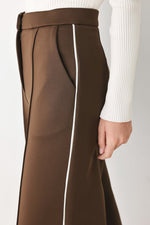 Brown pants close-up showing waistband, darts, and white side stripe panel