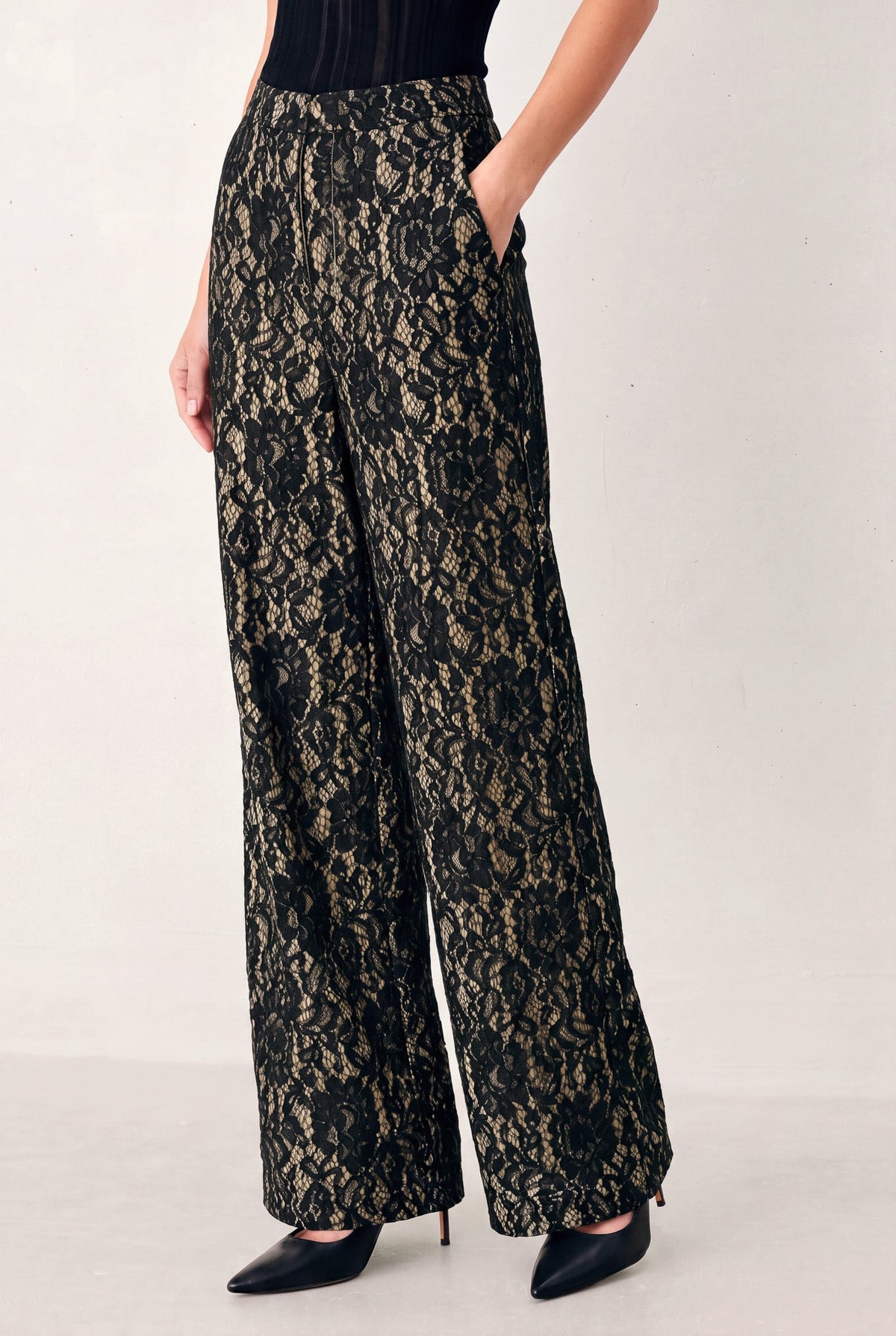 Black and camel lace wide-leg pants, side view showing relaxed roomy leg width