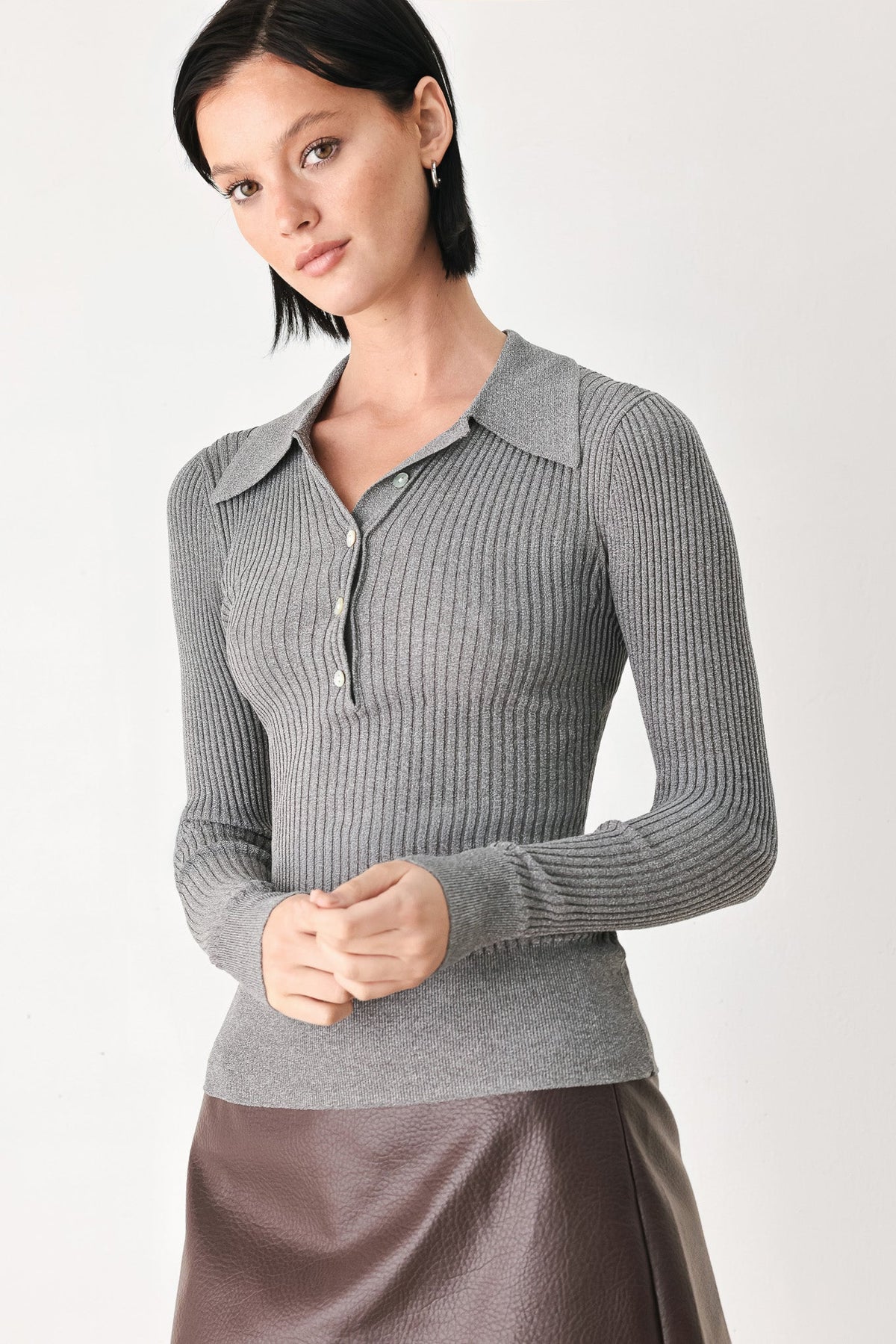 Grey ribbed knit polo top with short button placket, pointed collar, long sleeves.