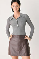 Grey ribbed knit polo top with pointed collar and button placket, long sleeves.