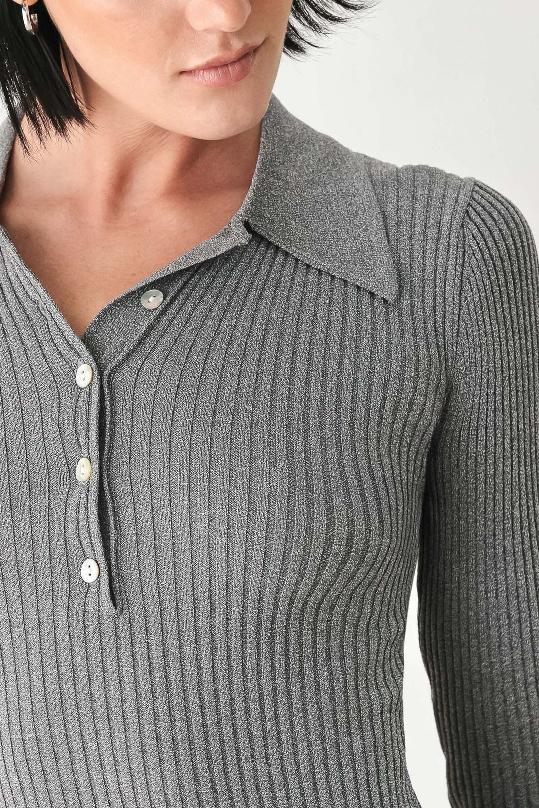 Close-up of grey ribbed knit polo top collar with button placket.