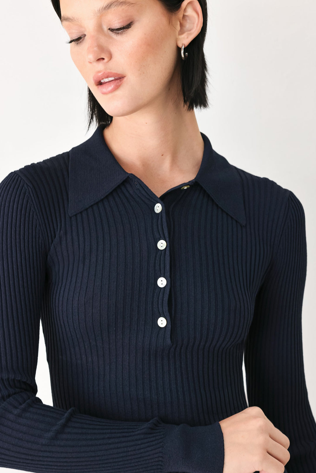 Navy ribbed knit polo top with button placket and pointed collar, long sleeves.