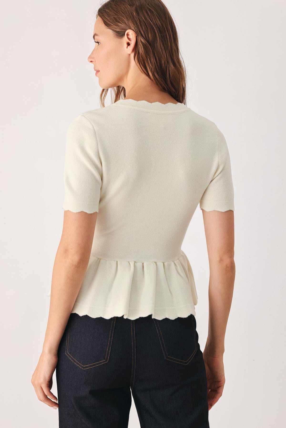 Cream knit sweater top back view with peplum hem and short sleeves