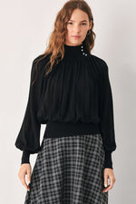 Black high-neck draped knit top with buttoned collar and voluminous long sleeves