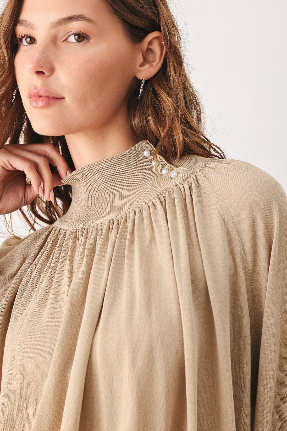 Taupe knit sweater top with ruffled neckline and faux pearl button detail