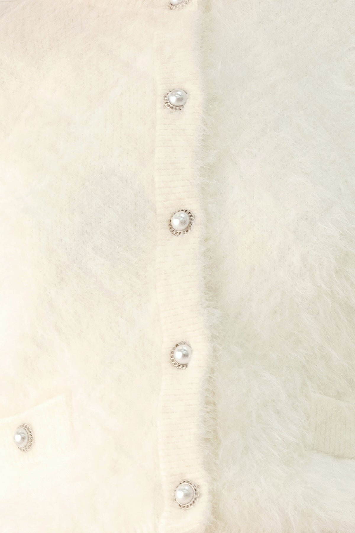 Ivory fuzzy cropped cardigan close-up of round button placket