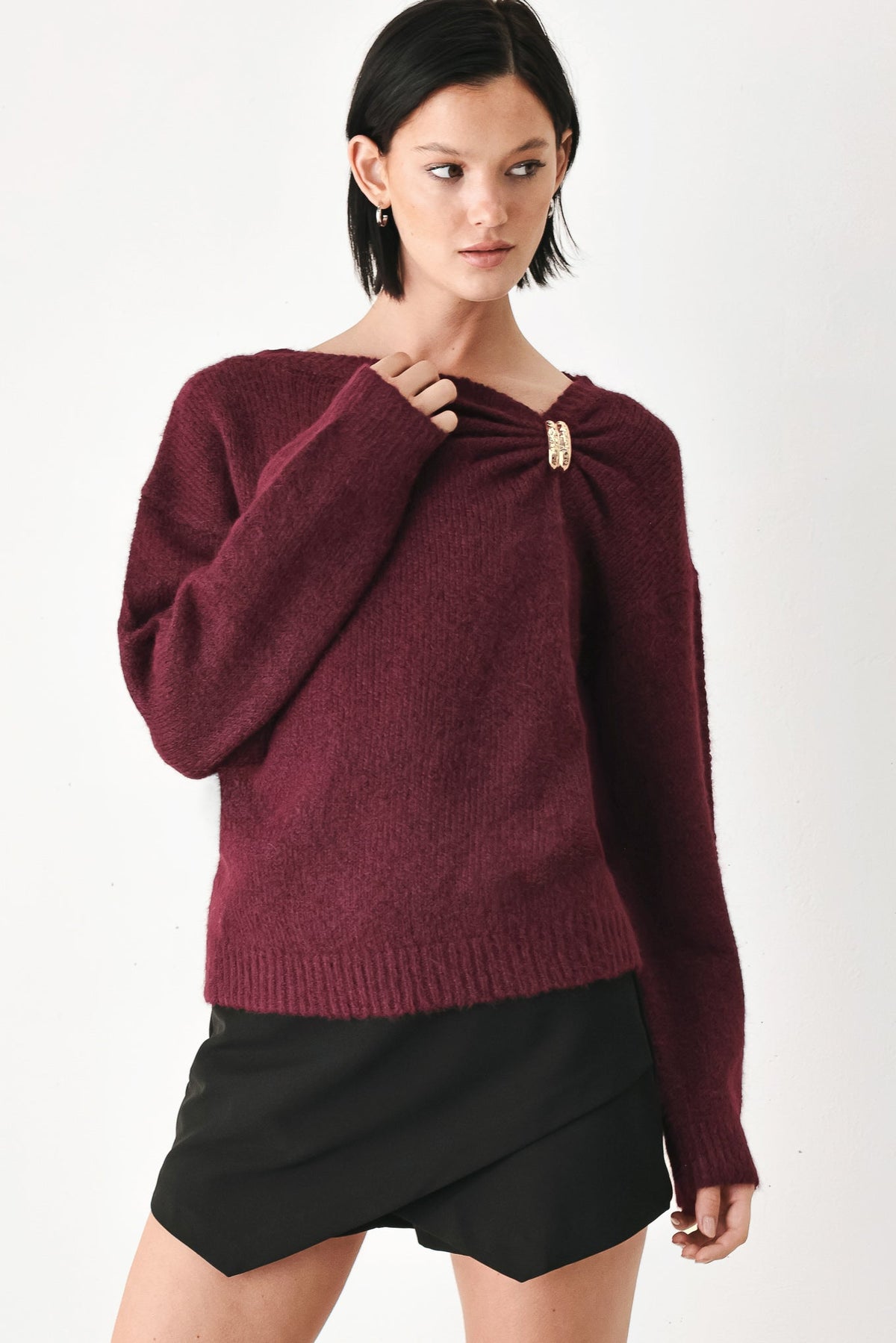 Burgundy cinched-neck sweater with long balloon sleeves and gold charm detail