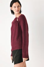 Burgundy knit sweater with cinched shoulder neckline and gold charm detail