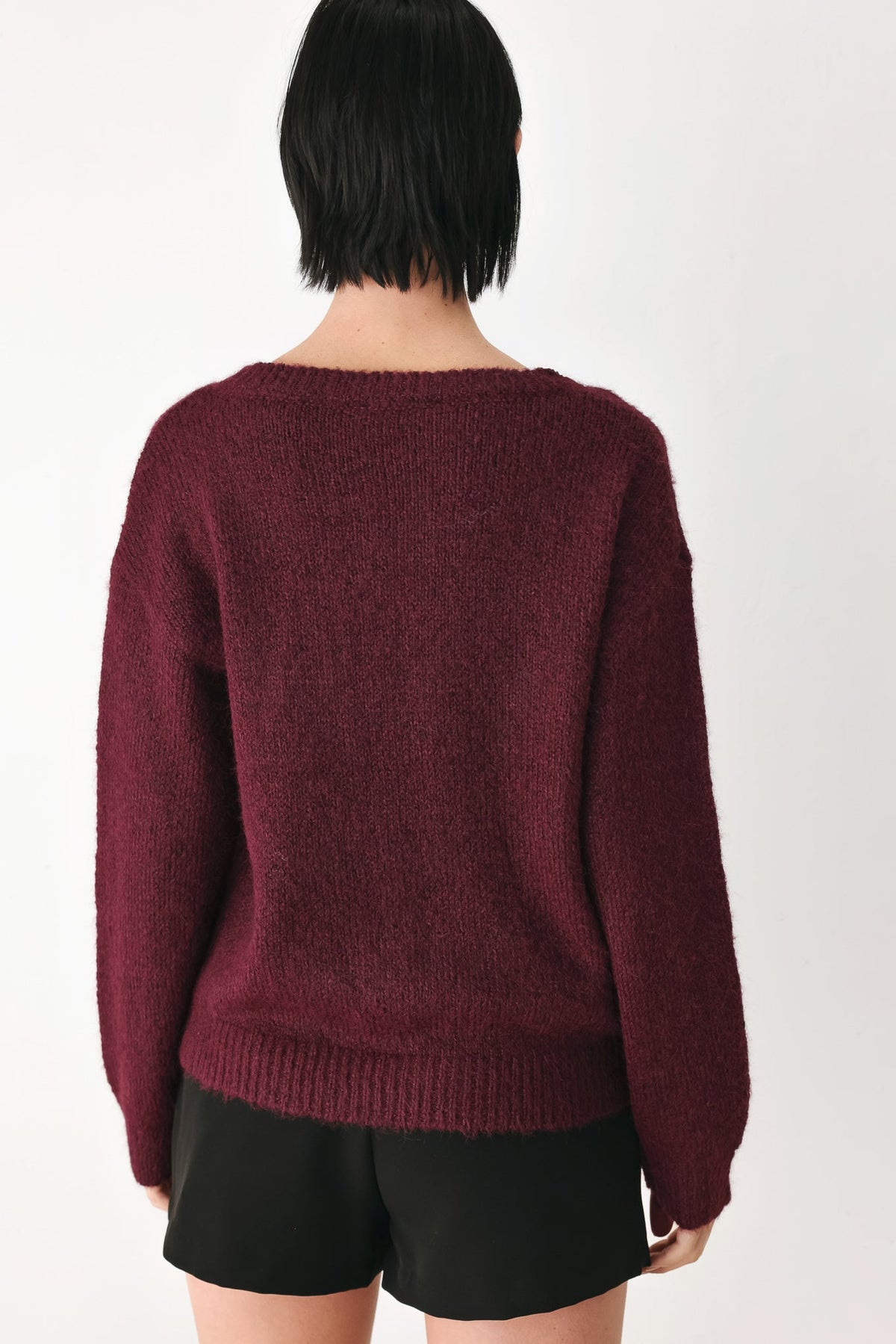 Burgundy knit sweater with cinched back neckline and long sleeves
