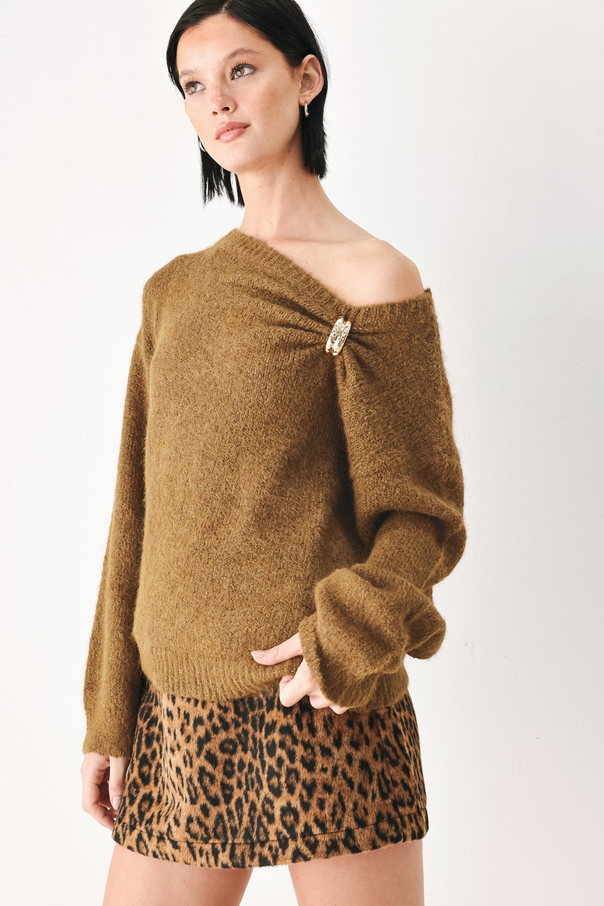 Camel brown cinched-neck sweater with long sleeves and gold charm at neckline