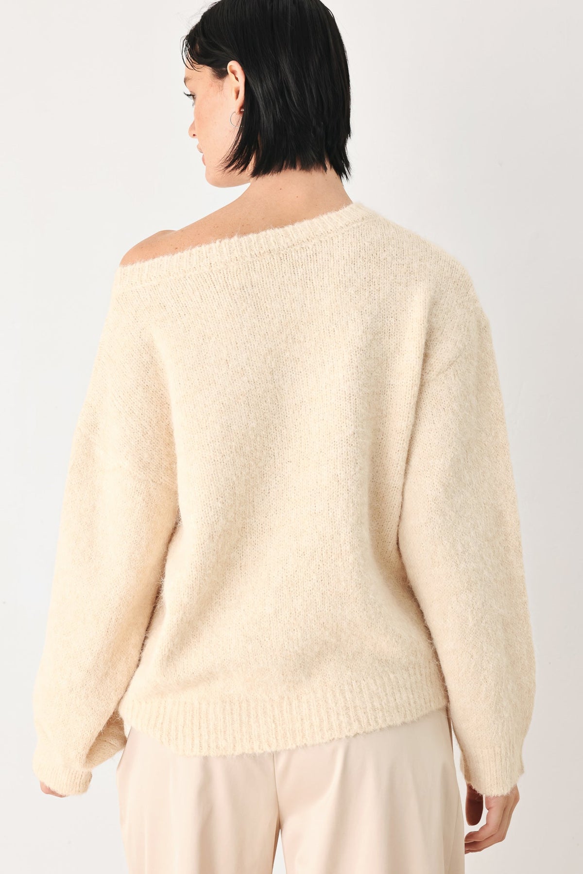 Ivory knit sweater with cinched back neckline and long sleeves