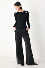 Black rib-knit classic sweater top with round neckline, long sleeves, shoulder buttons