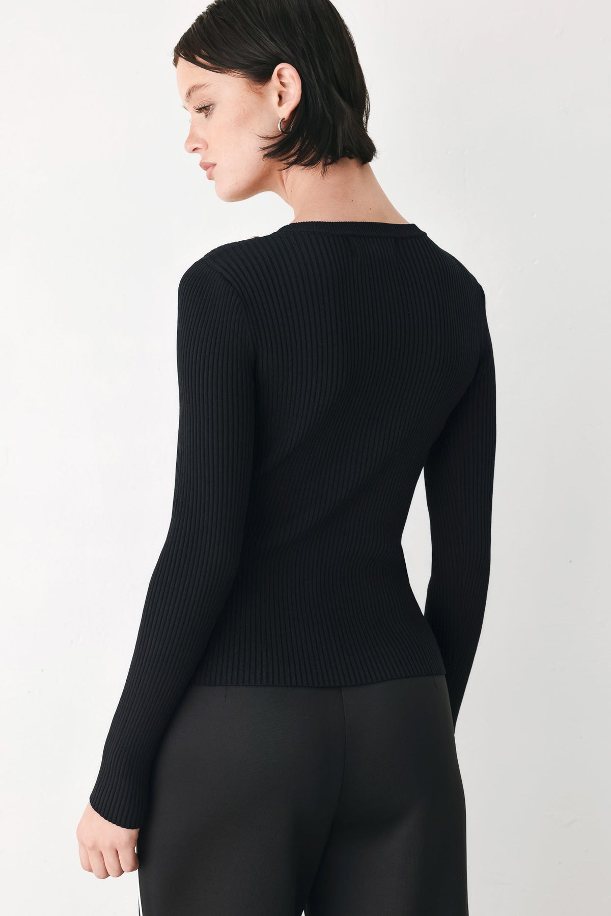 Black ribbed knit sweater top, back view, with long sleeves and crew neckline
