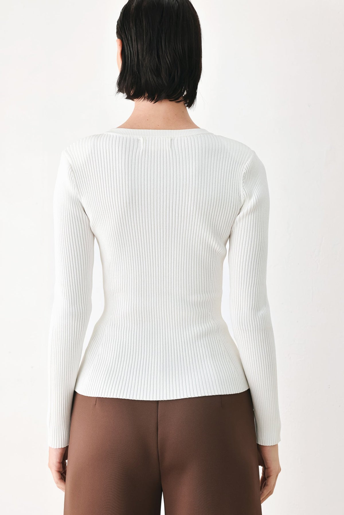 Off-white ribbed knit sweater top, back view, with long sleeves and crew neckline