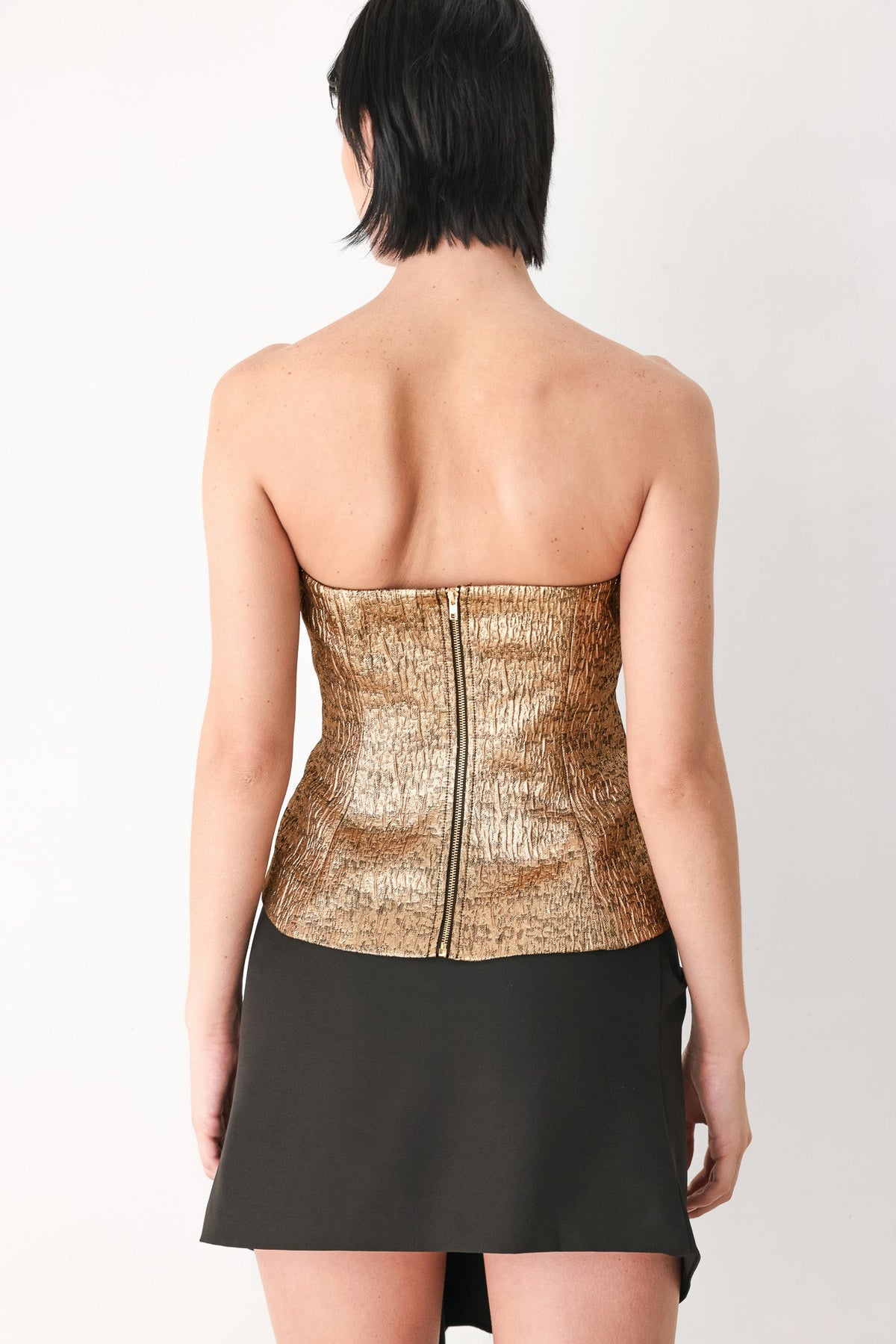 Gold metallic tube top with strapless corset back and center zipper, peplum hem