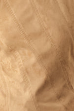Camel faux suede fabric close-up with stitched diagonal seam lines