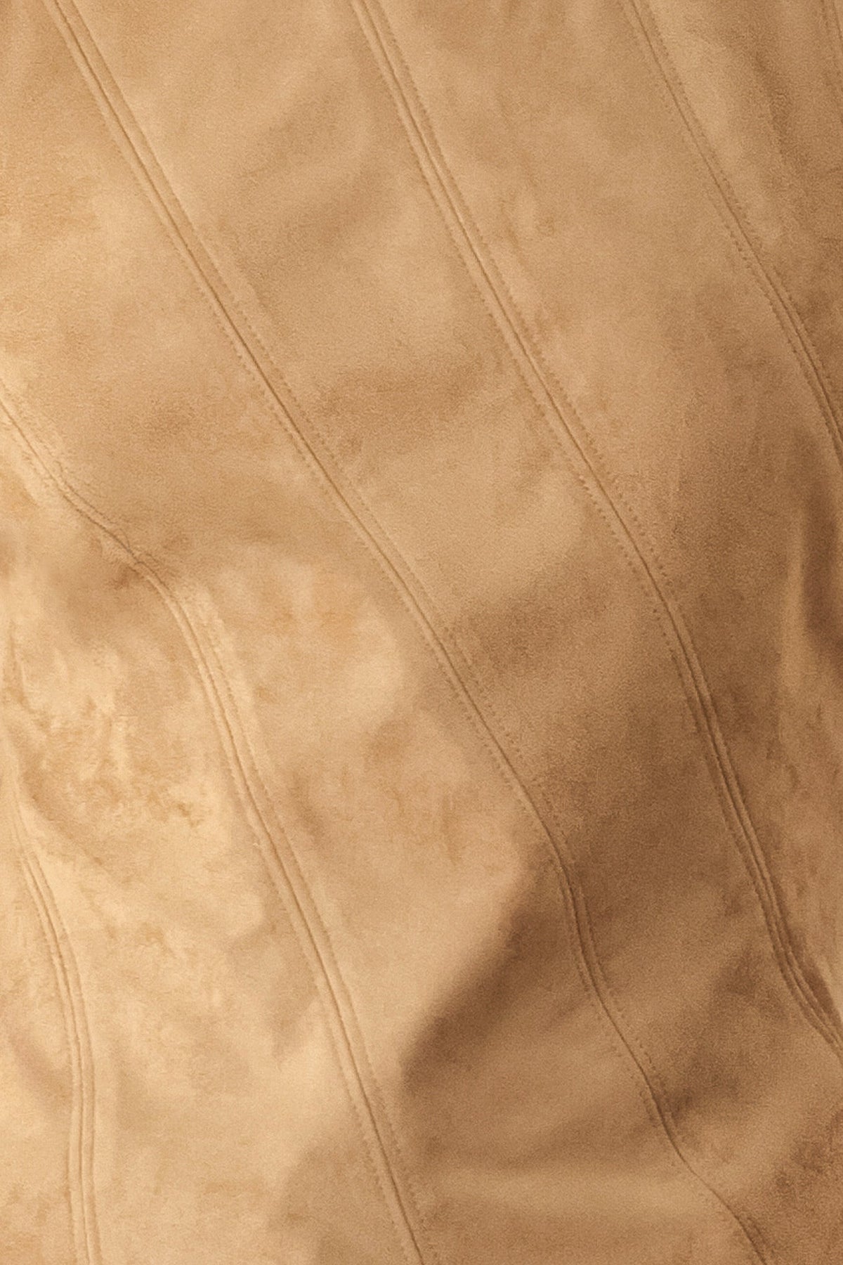 Camel faux suede fabric close-up with stitched diagonal seam lines