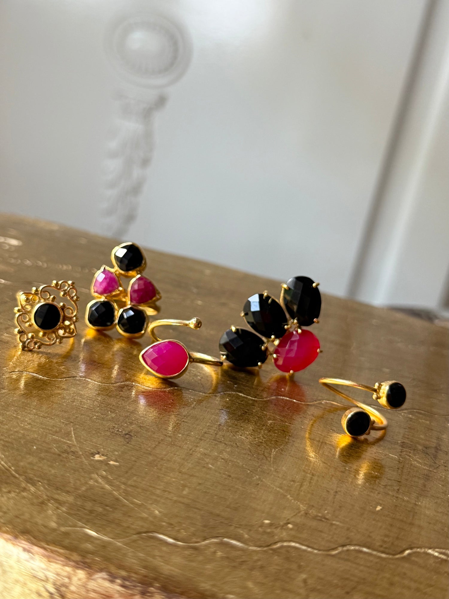Gold-tone ring set with black and pink gemstones on display