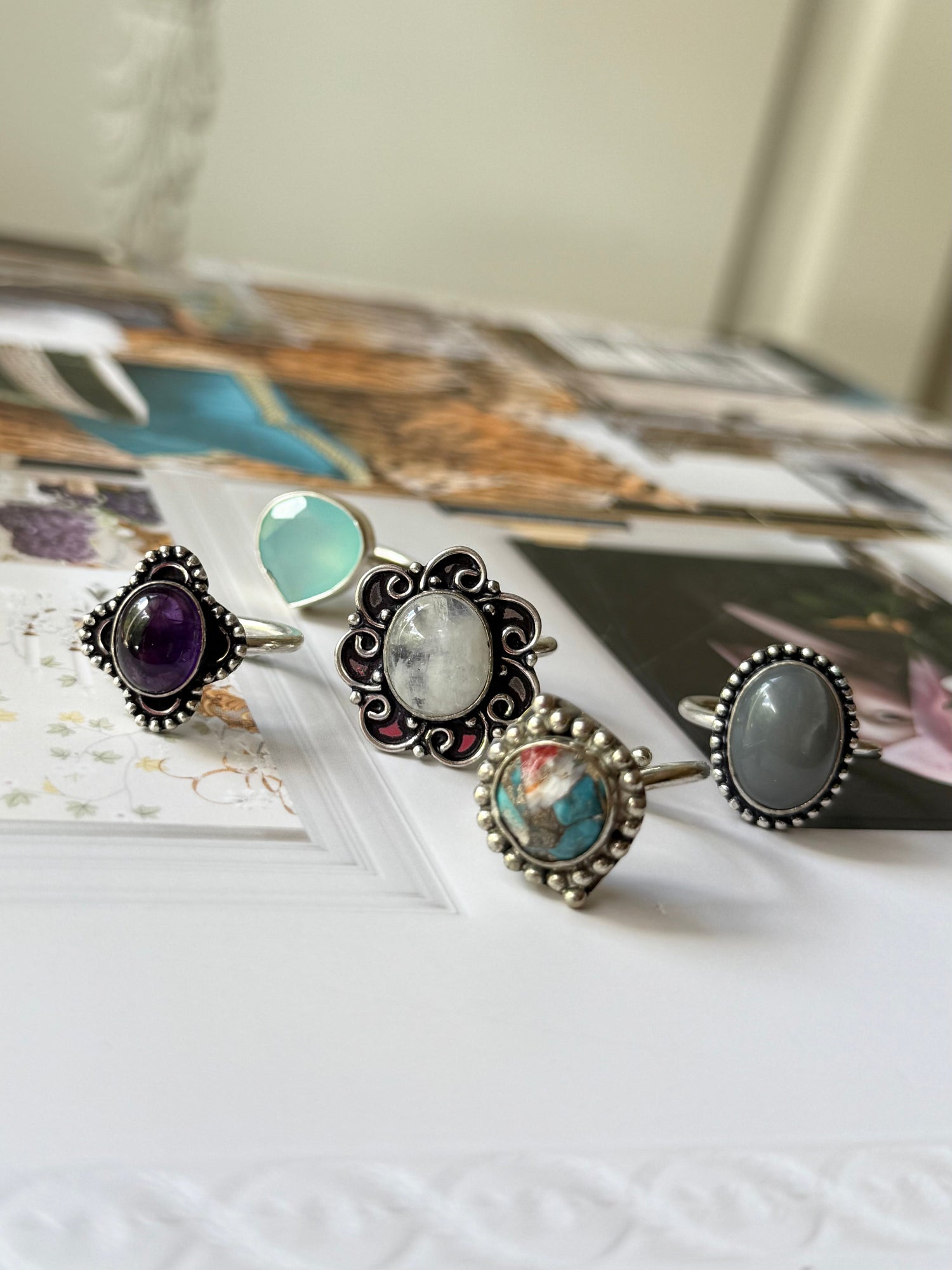 Silver-tone ring set with purple, teal, and clear oval stones in ornate settings