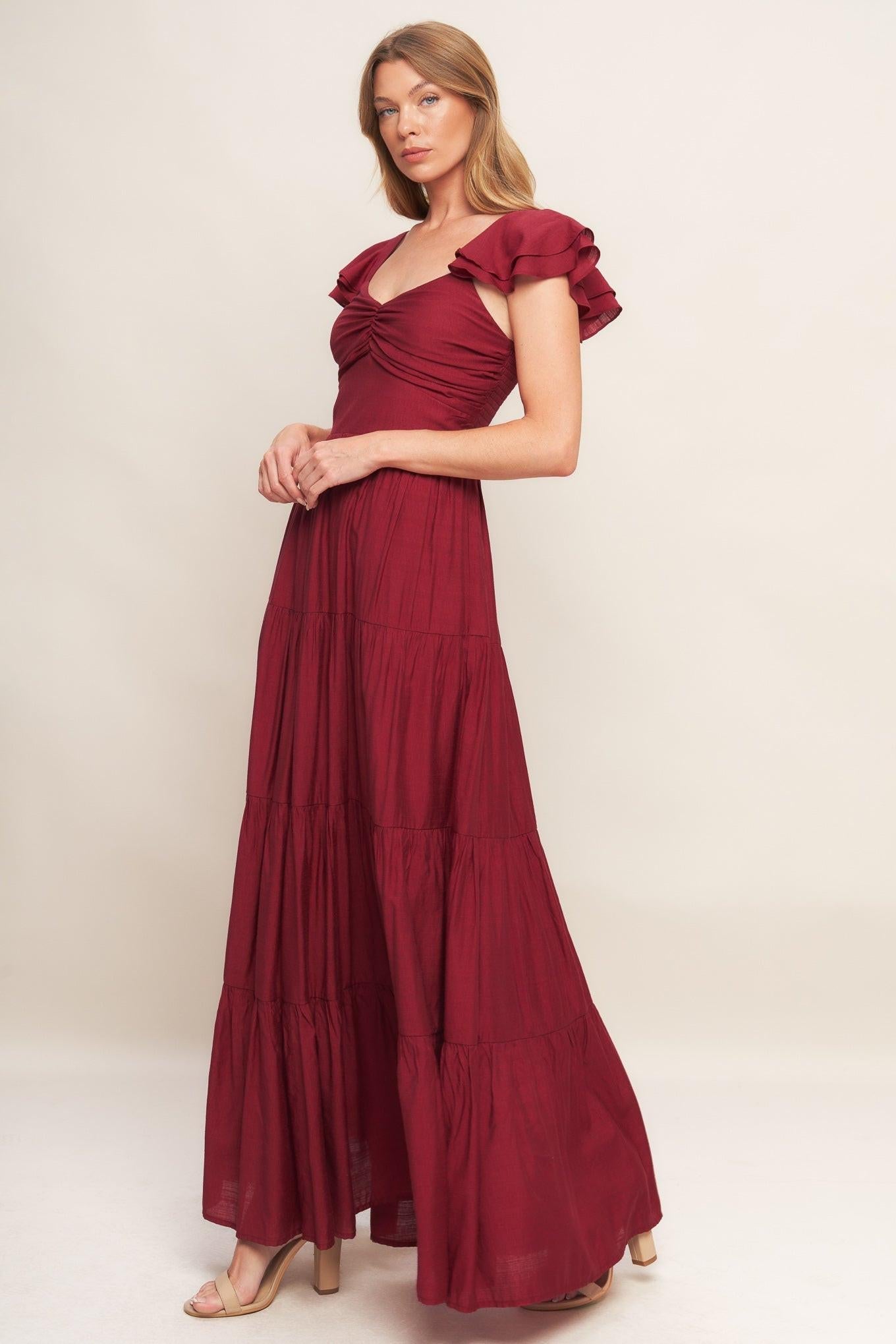 Deep red woven maxi dress with square neckline and ruffled cap sleeves, tiered skirt