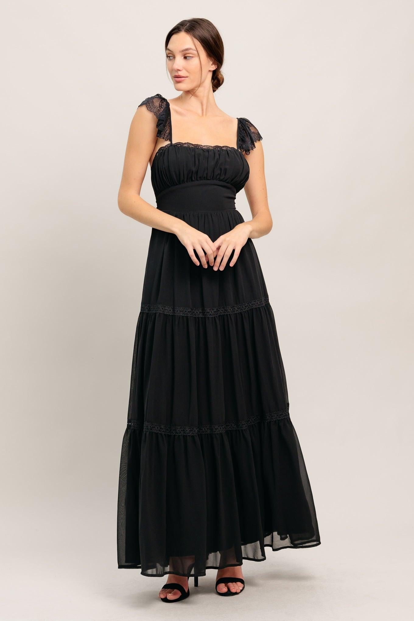 Black woven maxi dress with smocked bodice, lace cap sleeves, tiered skirt, square neckline.