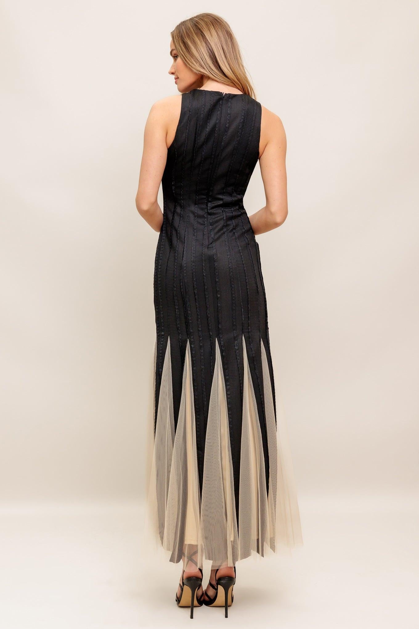 Black sleeveless maxi dress with high neckline and V-shaped tulle hem overlay