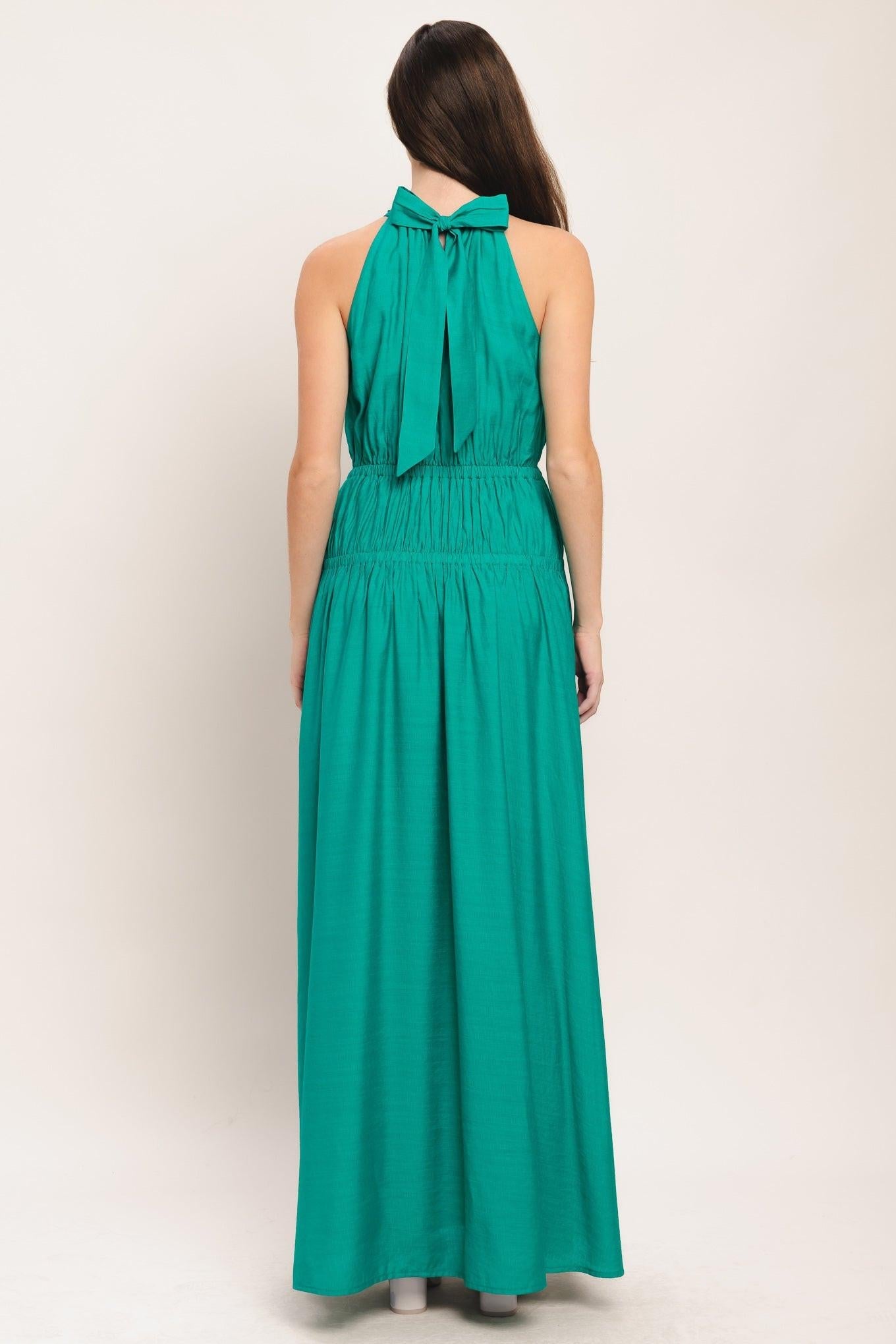 Back view of teal woven maxi dress with halter tie, smocked waist, tiered skirt