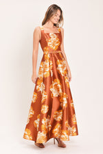 Rust maxi dress with flowing skirt and orange floral blooms, sleeveless bodice, belt