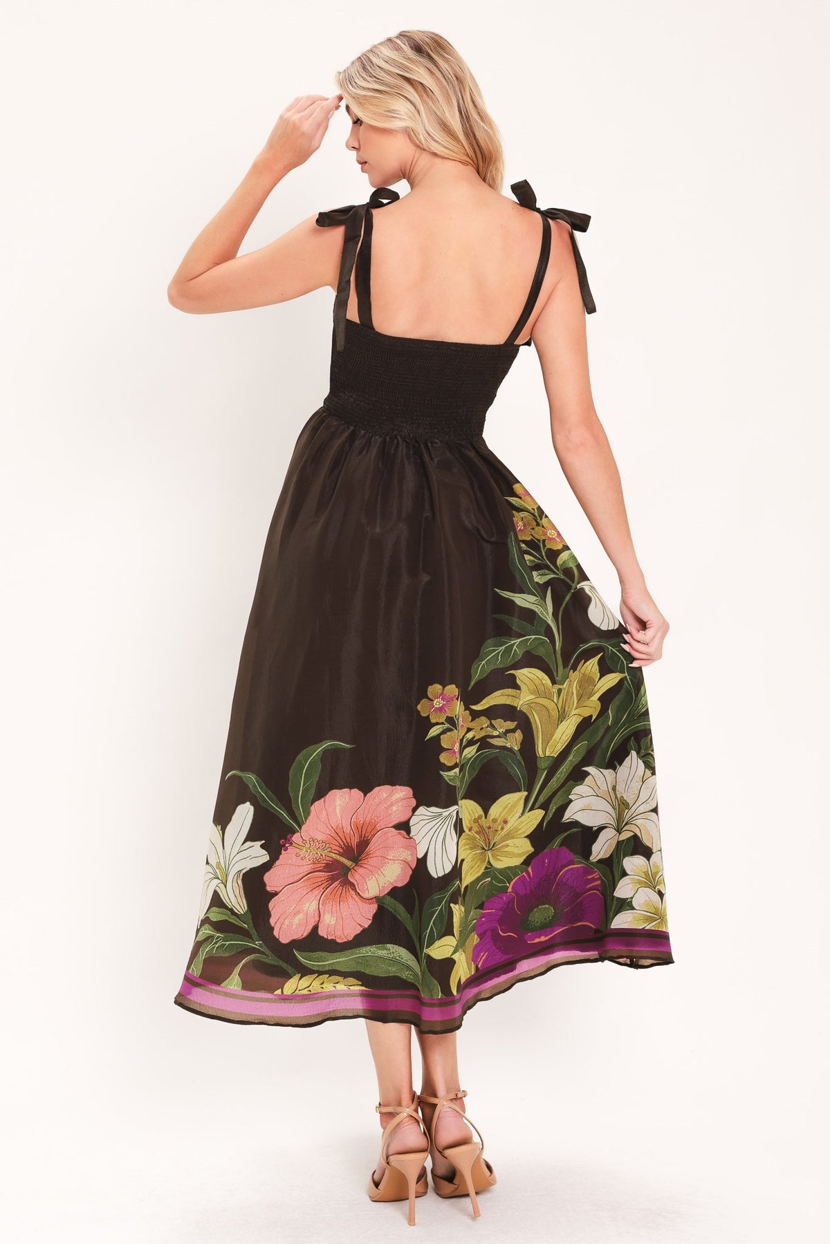 Back view of brown woven midi dress with bow straps and floral hem border