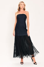 Dark indigo denim strapless tube dress with layered black tulle midi skirt and heels
