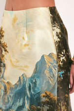 Woven skirt close-up: cream panel with blue mountain and foliage pattern