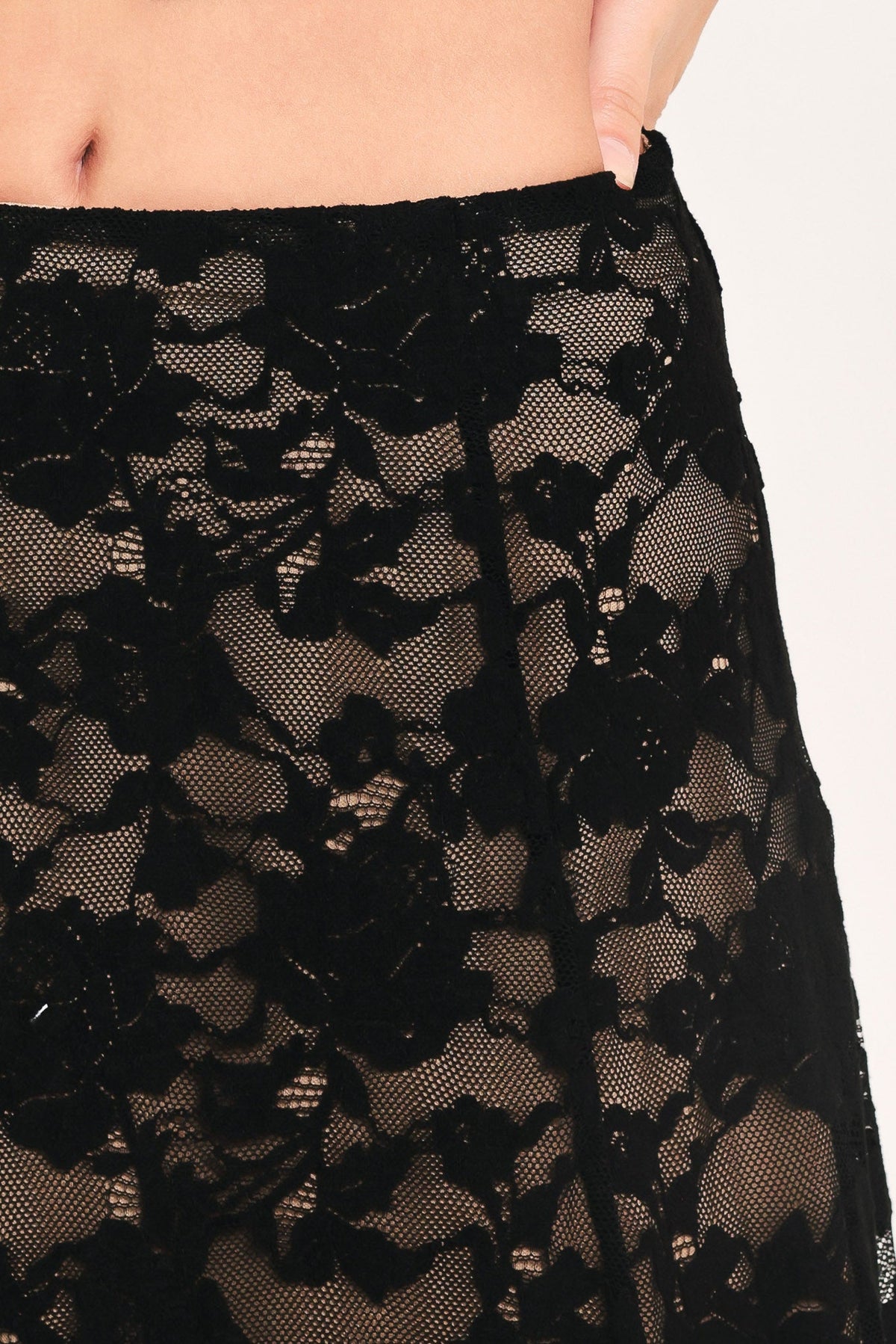 Black lace skirt detail with dense floral pattern and sheer mesh overlay