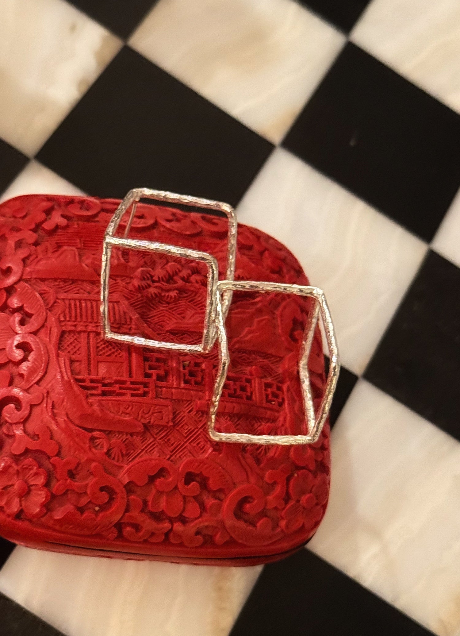Red textured mini bag with two square silver buckles and top handle