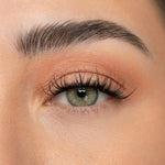 Curled dark eyelash extensions on open eye, dramatic volume and length