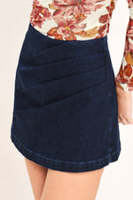 Dark indigo denim skort with front pocket panel and stitched curved hem