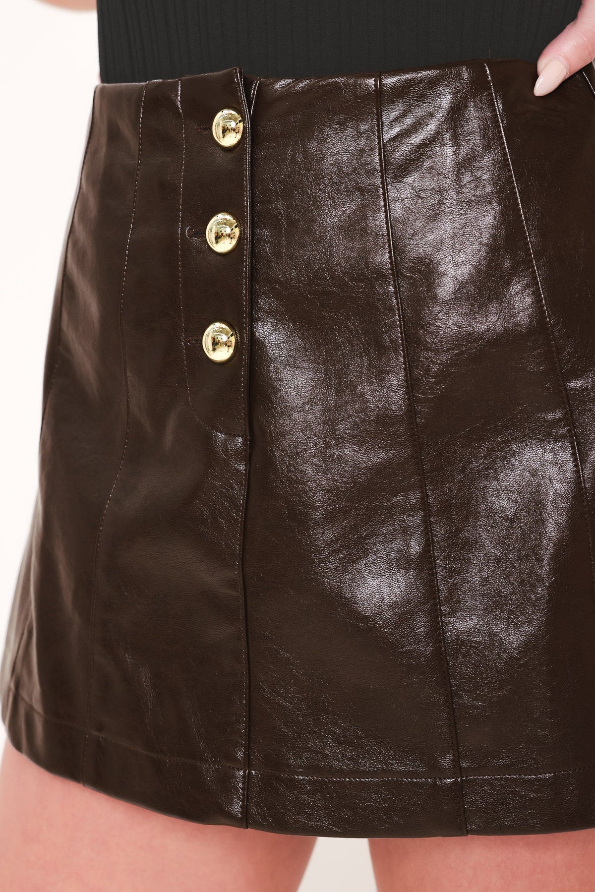 Dark brown faux leather skort with gold buttons and vertical seam stitching