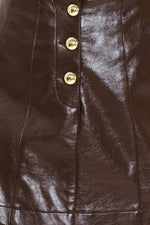 Dark brown faux leather skort close-up: gold buttons on front placket