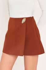 Rust Tencel skort with side zip and gold-toned tab, angled front overlap seam