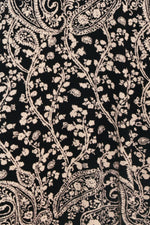 Close-up of black-and-cream paisley jacquard pattern on a sweater dress