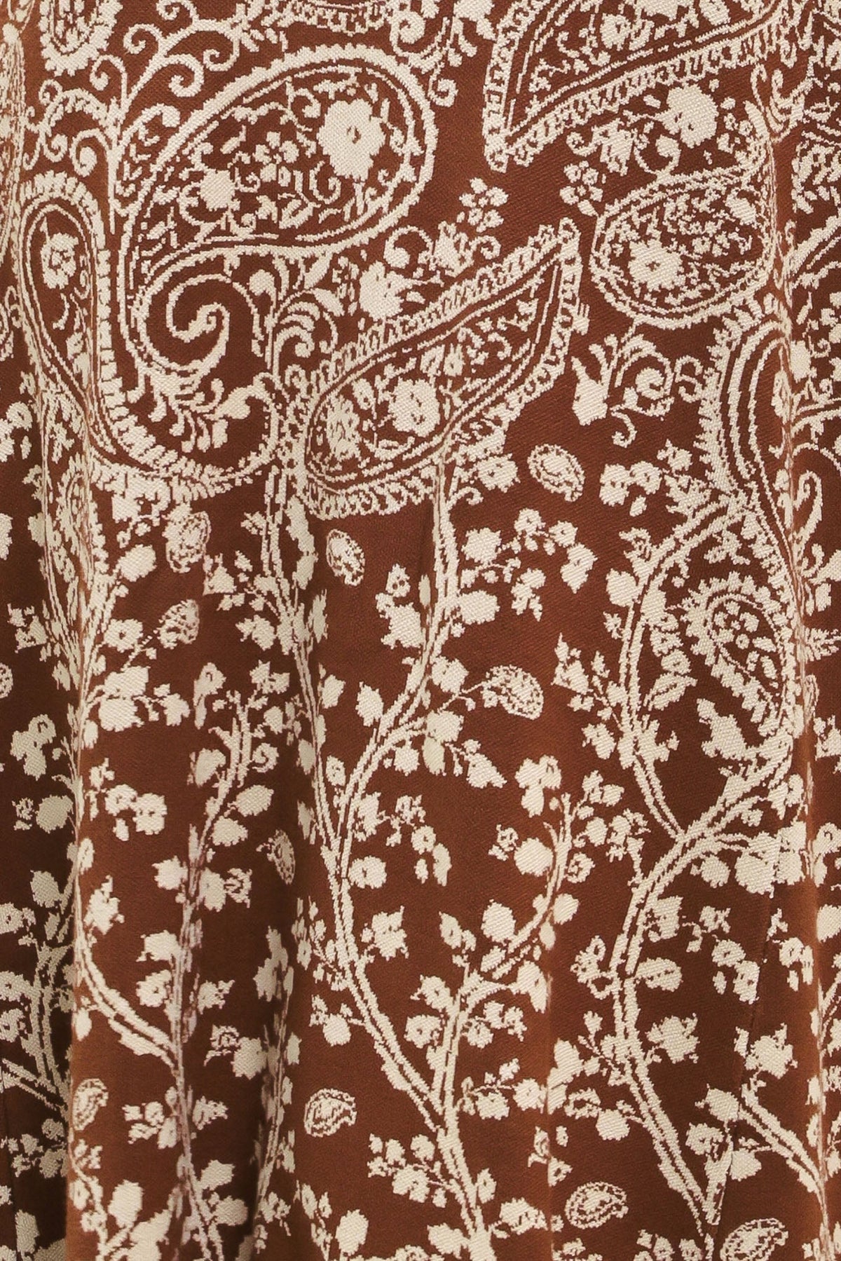 Camel-brown jacquard knit fabric with ornate white paisley motifs