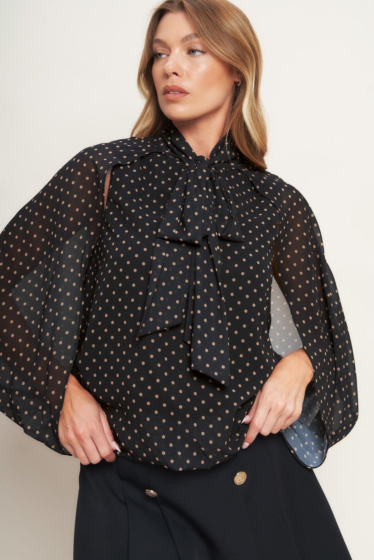 Black woven top with small gold dots, bow neck and layered ruffle front