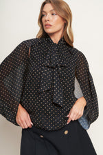Black woven top with small gold dots, bow neck and layered ruffle front